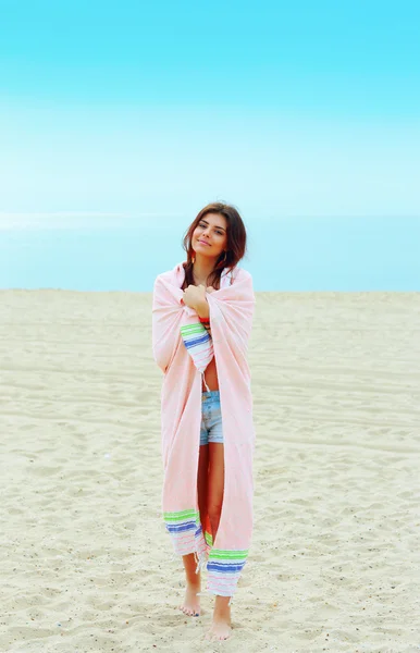Frau wickelte sich mit Decke am Strand ein — Stockfoto
