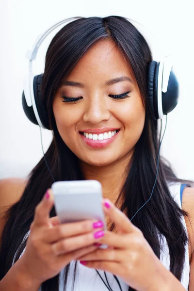 Ung asiatisk kvinna i hörlurar lyssna på musik — Stockfoto
