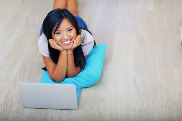 Ung vacker asiatisk kvinna sitter på golvet med laptop — Stockfoto