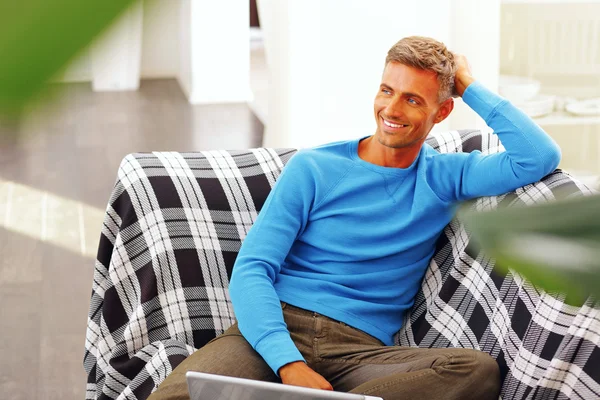 Hombre joven guapo usando el ordenador portátil en casa — Foto de Stock