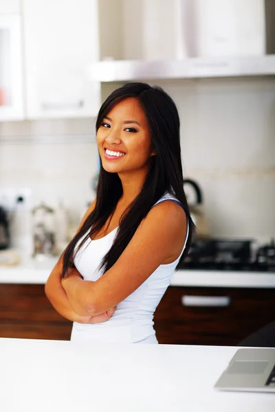 Unga glada asiatisk kvinna med armarna vikta hemma — Stockfoto