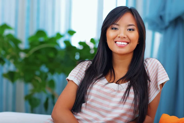 Beautiful asian woman in casual clothings sitting on the sofa — Stock Photo, Image