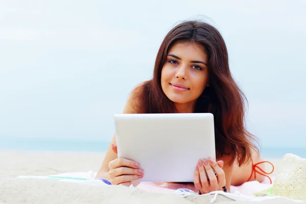 Mooie vrouw in zwemmen pak met behulp van haar Tablet PC op het strand — Stockfoto