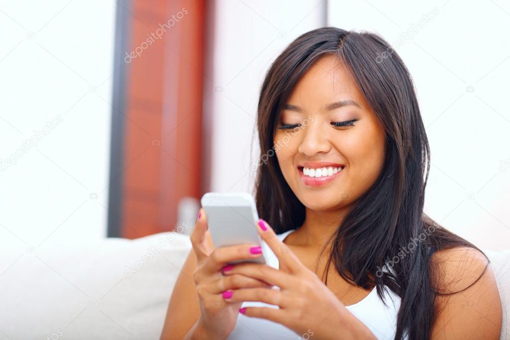 Young asian woman text messaging with her smartphone