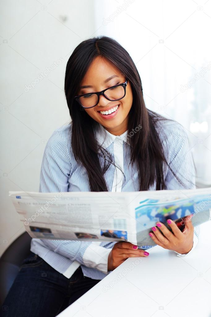 Asian businesswoman reading newspaper