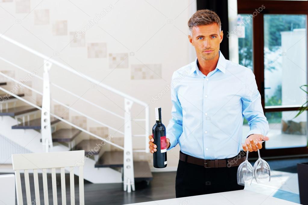 Man carrying a bottle of wine with two glasses — Stock Photo
