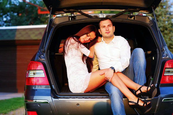 Romantic couple sitting in a trunk — Stock Photo, Image
