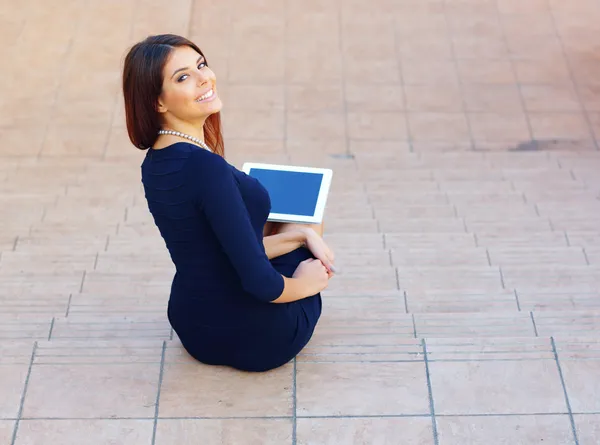 Student sitting on stairs with a tablet computer — Stock Photo, Image