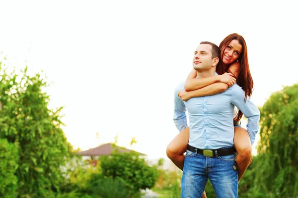 Mulher feliz pulou nas costas do homem — Fotografia de Stock