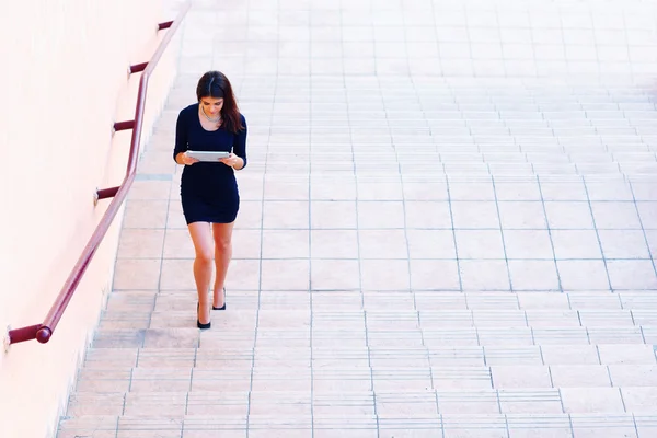 Businesswoman going up the stairs with tablet computer — Stock Photo, Image