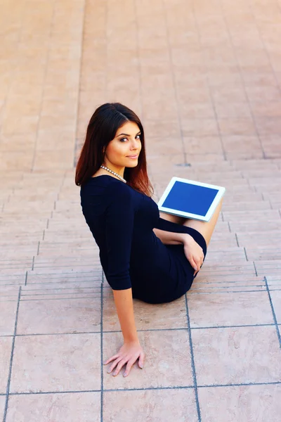 Student sitting on stairs with a tablet computer — Stock Photo, Image