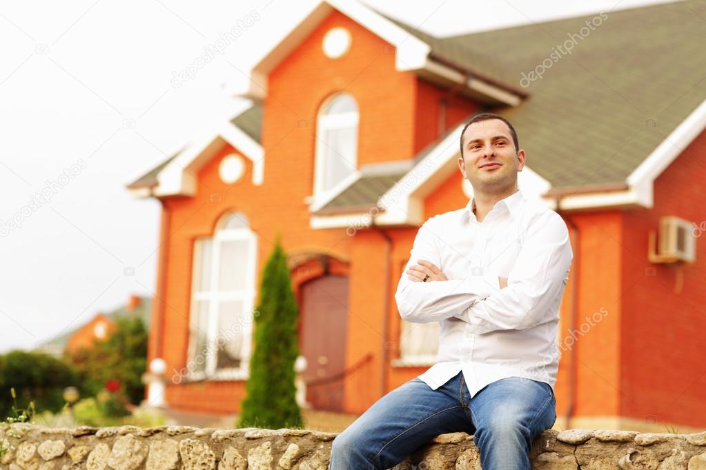 Man in front of his own house.