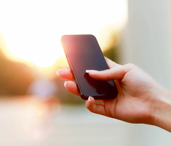 Kvinnlig hand med en smart telefon — Stockfoto