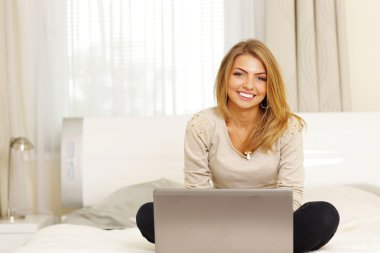 laptop ile yatakta yatarken kadın