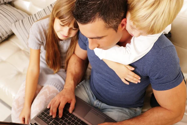 Père avec des enfants travaillant sur un ordinateur portable — Photo