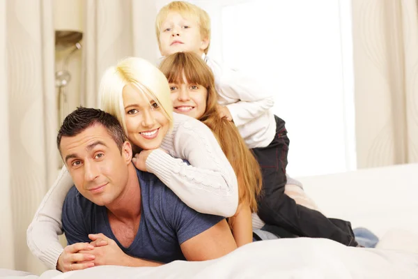 Familia acostada en la cama — Foto de Stock