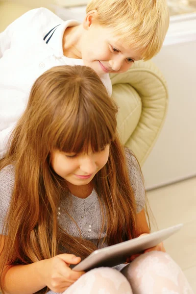 Irmão e irmã jogando no computador tablet — Fotografia de Stock