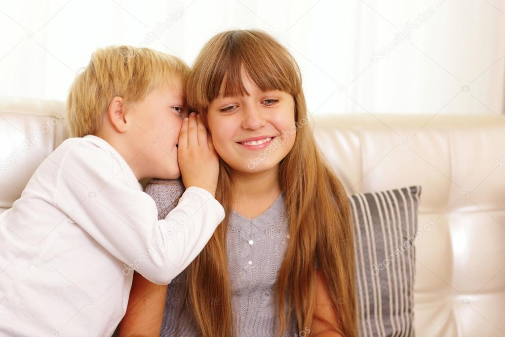Boy whispers to sister