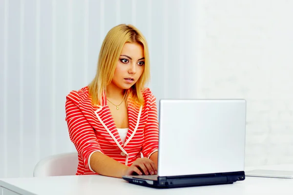 Überraschte Frau schaut auf Laptop — Stockfoto