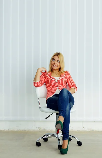 Fröhliche Frau auf dem Stuhl sitzend — Stockfoto