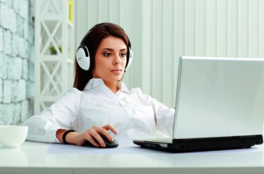 bir dizüstü bilgisayarda çalışma kulaklık iş kadını