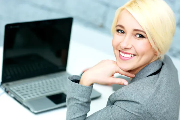 Femme d'affaires assis à son lieu de travail avec ordinateur portable — Photo