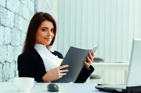 Affärskvinna läsa anteckningsboken i office — Stockfoto