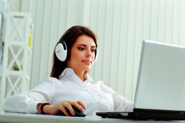 bir dizüstü bilgisayarda çalışma kulaklık iş kadını