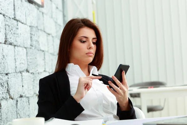 Affärskvinna tittar på skärmen av smartphone — Stockfoto