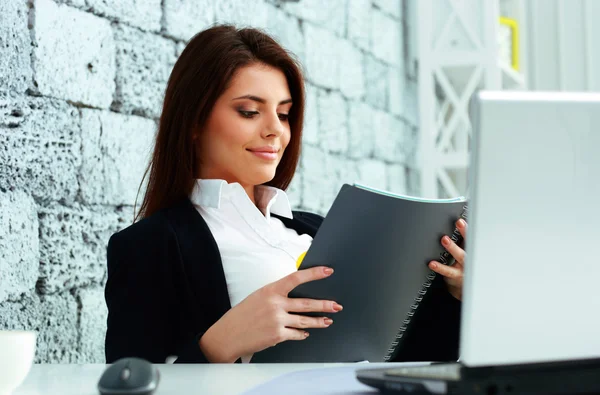 Businesswoman reading the notebook in office — Stock Photo, Image
