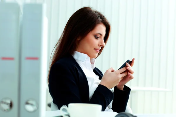 Mujer de negocios escribiendo en su teléfono inteligente — Foto de Stock