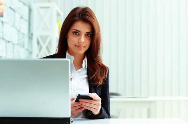 Mujer de negocios seria sosteniendo teléfono inteligente — Foto de Stock