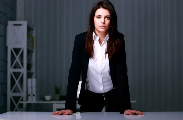 Businesswoman standing near the table in office — Stock Photo, Image