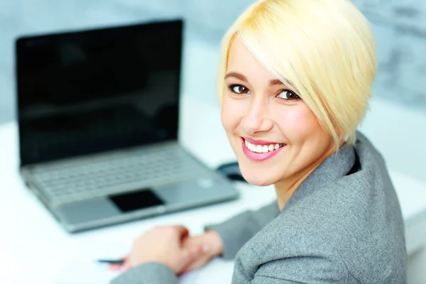 Joven empresaria sonriente en oficina — Stok fotoğraf