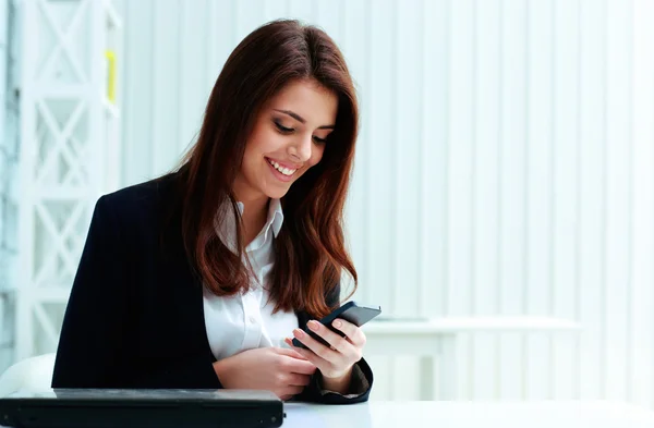 Businesswoman typing on her smartphone — Stock Photo, Image