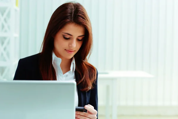 Young businesswoman looking at smartphone — Stock Photo, Image