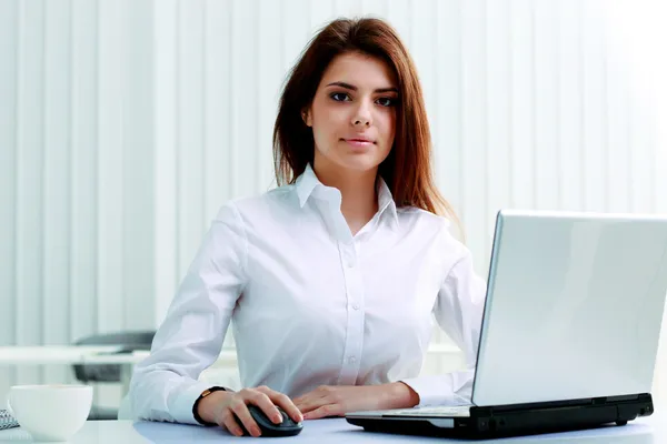 İş kadını elinde dizüstü bilgisayarla masada oturuyor. — Stok fotoğraf