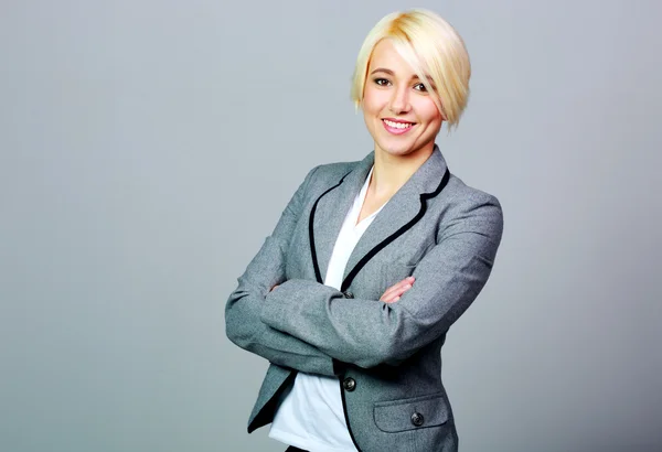 Mujer de negocios sonriente de pie con los brazos cruzados — Foto de Stock