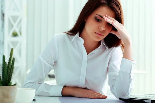 Mujer de negocios pensativa sentada a la mesa — Foto de Stock