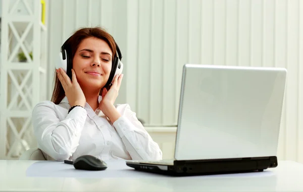 Zakenvrouw luisteren muziek in hoofdtelefoon — Stockfoto