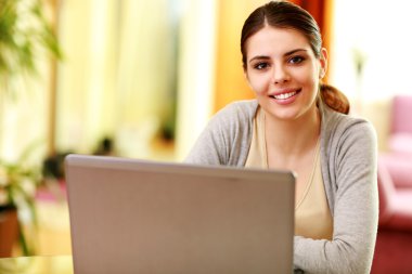 laptop ile masaya oturan kadın