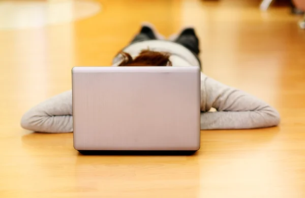 Femme couchée sur le sol avec ordinateur portable — Photo