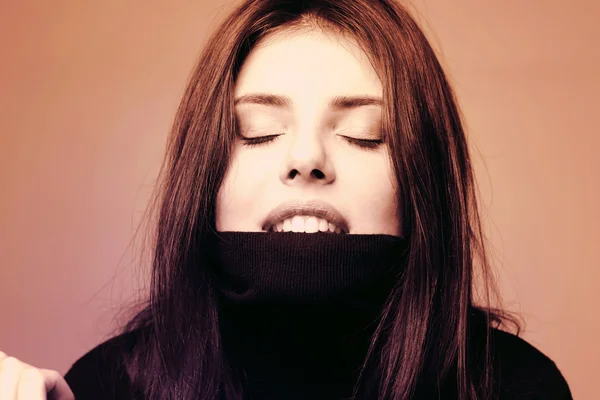 Молодая женщина кусает свой свитер — стоковое фото
