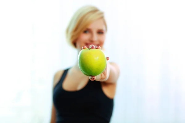 Female hand holding green apple — Stock Photo, Image