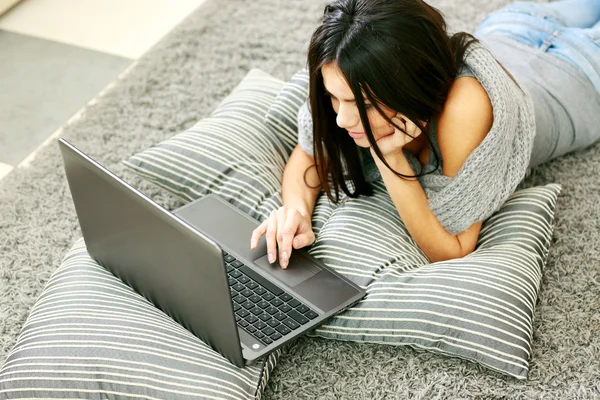 Vrouw met laptop op de vloer liggen — Stockfoto