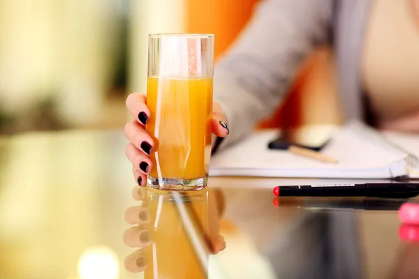 Woman hand holding glass of orange juice — Stock Photo, Image