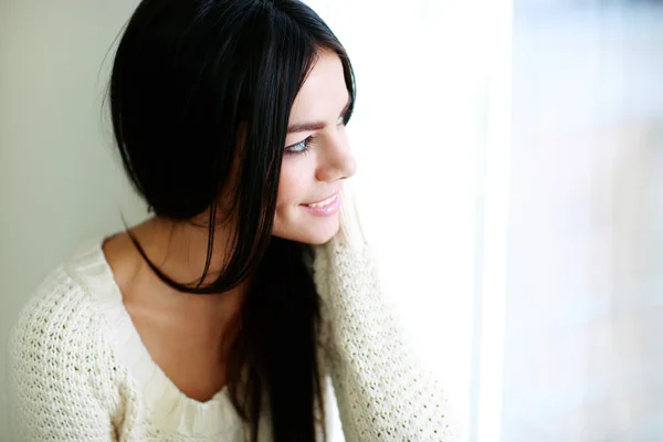 Young happy woman looking at window — Stock Photo, Image