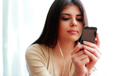 kadın Smartphone kullanarak ve müzik dinleme