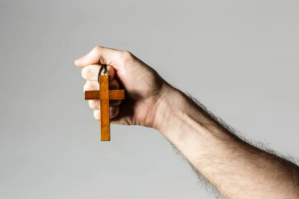 Mains masculines tenant la croix en bois — Photo