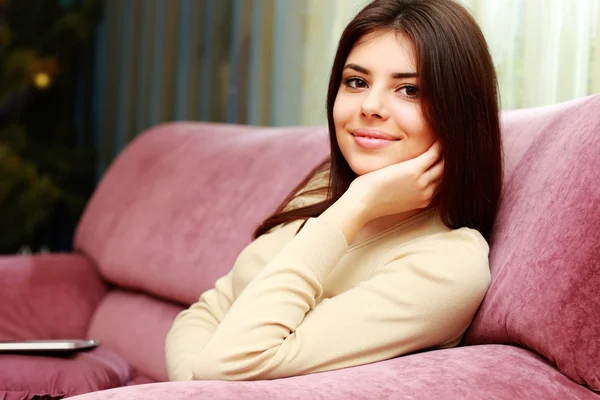 Женщина сидит дома на диване — стоковое фото